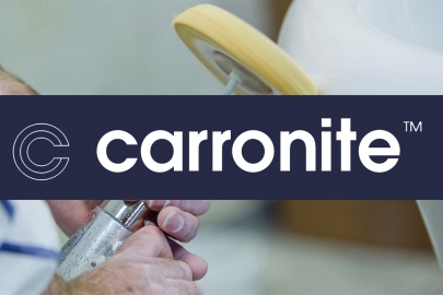 Image showing a Carronite bath being finished by hand - with Carronite logo