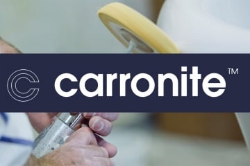 Image showing a Carronite bath being finished by hand - with Carronite logo