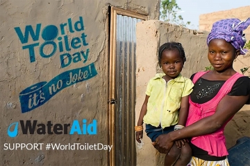 An image from water aid uk showing a family standing next to a toilet for world toilet day as part of what is world toilet day by heatandplumb.com